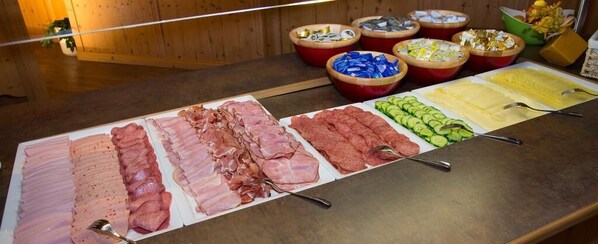 Un bufé con diferentes carnes y verduras.