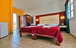 A hotel room with a bed, a wardrobe, a desk, and a window with curtains. - Aegeon (Lesvos)