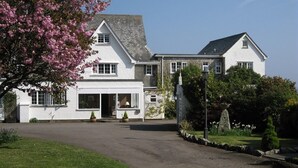 A large, white two-story house with a driveway leading to the entrance. - Trelawne Hotel (Falmouth)