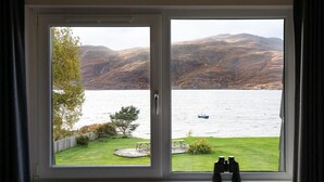 A window with a view of a lake and hills. - Harbour House Bed & Breakfast (Ullapool)