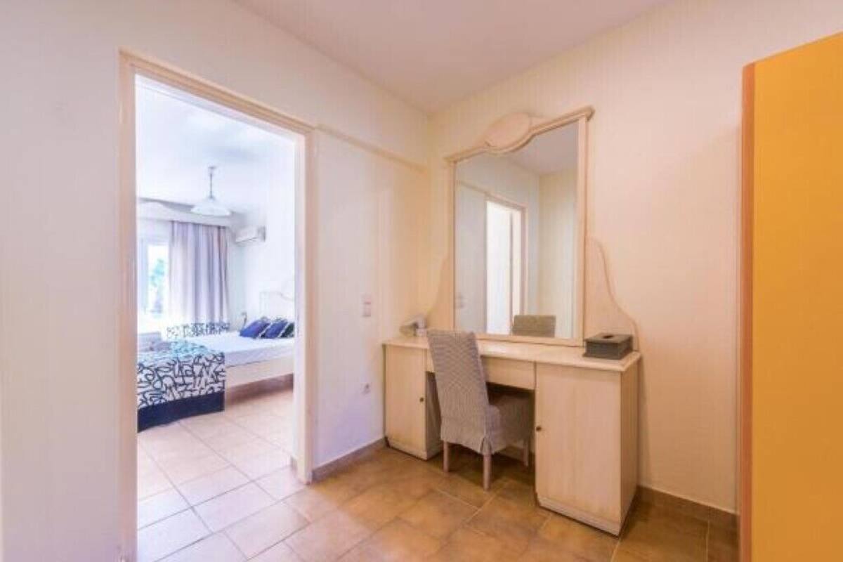Ein Schlafzimmer mit einem Bett, einem Schreibtisch, einem Stuhl und einem großen Spiegel.