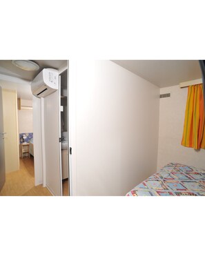 Un dormitorio con cama, armario y aire acondicionado.