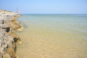 On the beach, sun loungers, beach umbrellas, windsurfing