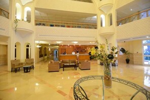A spacious lobby with a reception desk, seating area, and a decorative vase with flowers. - Sidi Mansour Resort & Spa (Djerba Midun)