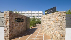A stone entrance gate with signs for "Prestige" and "Eliminor Bar Restaurant" leading to a building.