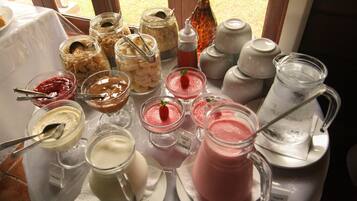 Variedad de opciones de comida y bebida, incluyendo botes de granola, tazones de yogur y una jarra de té helado.