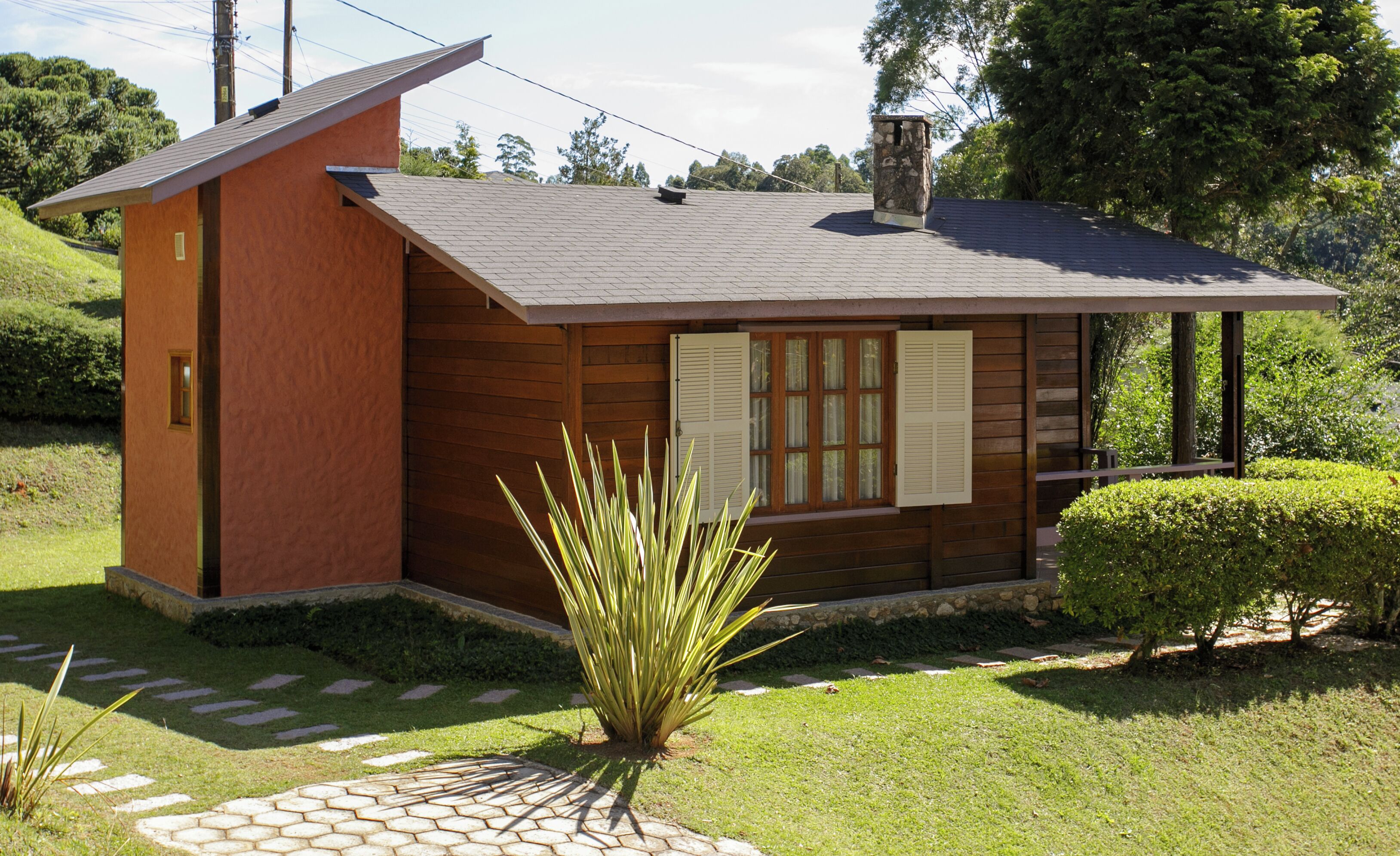 A small, single-story house with a sloped roof, wooden siding, and a small porch.