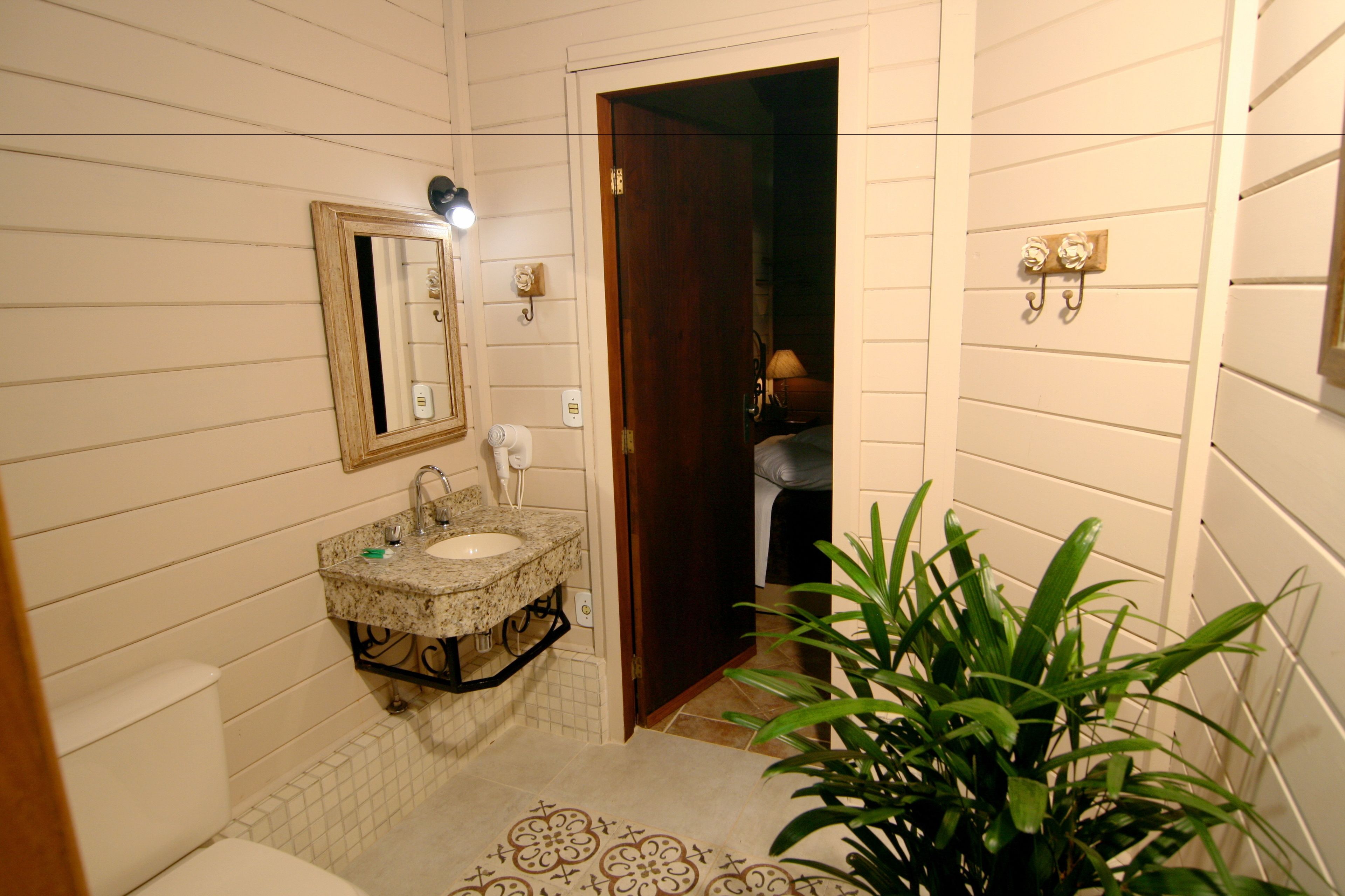 Une salle de bain avec un lavabo, un miroir et des toilettes.