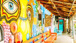 A wooden bench and a colorful mural with abstract designs. - Inn at the Art Center (San Angelo)