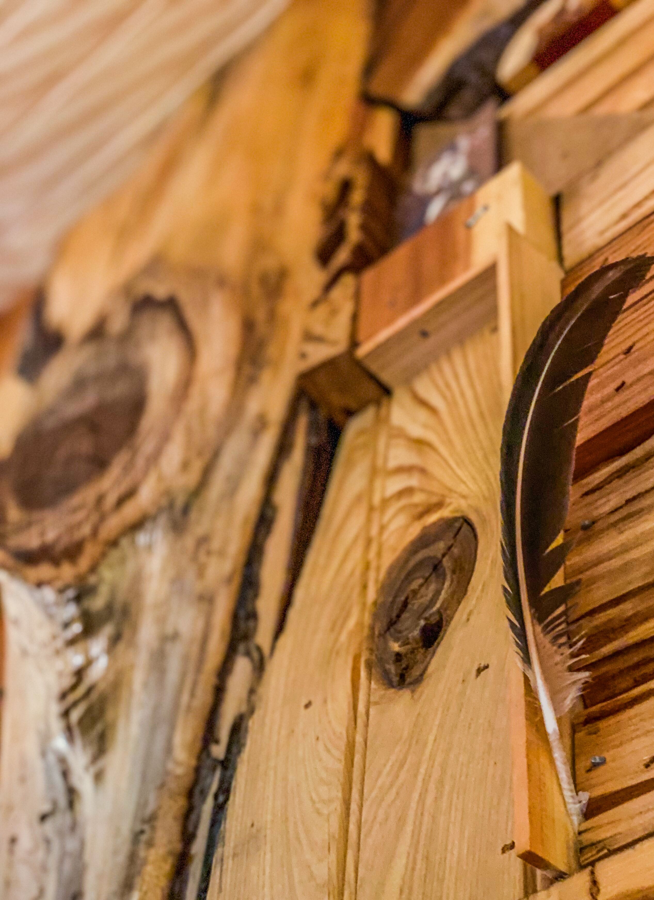 A close-up of a wooden wall with visible grain patterns and knots.