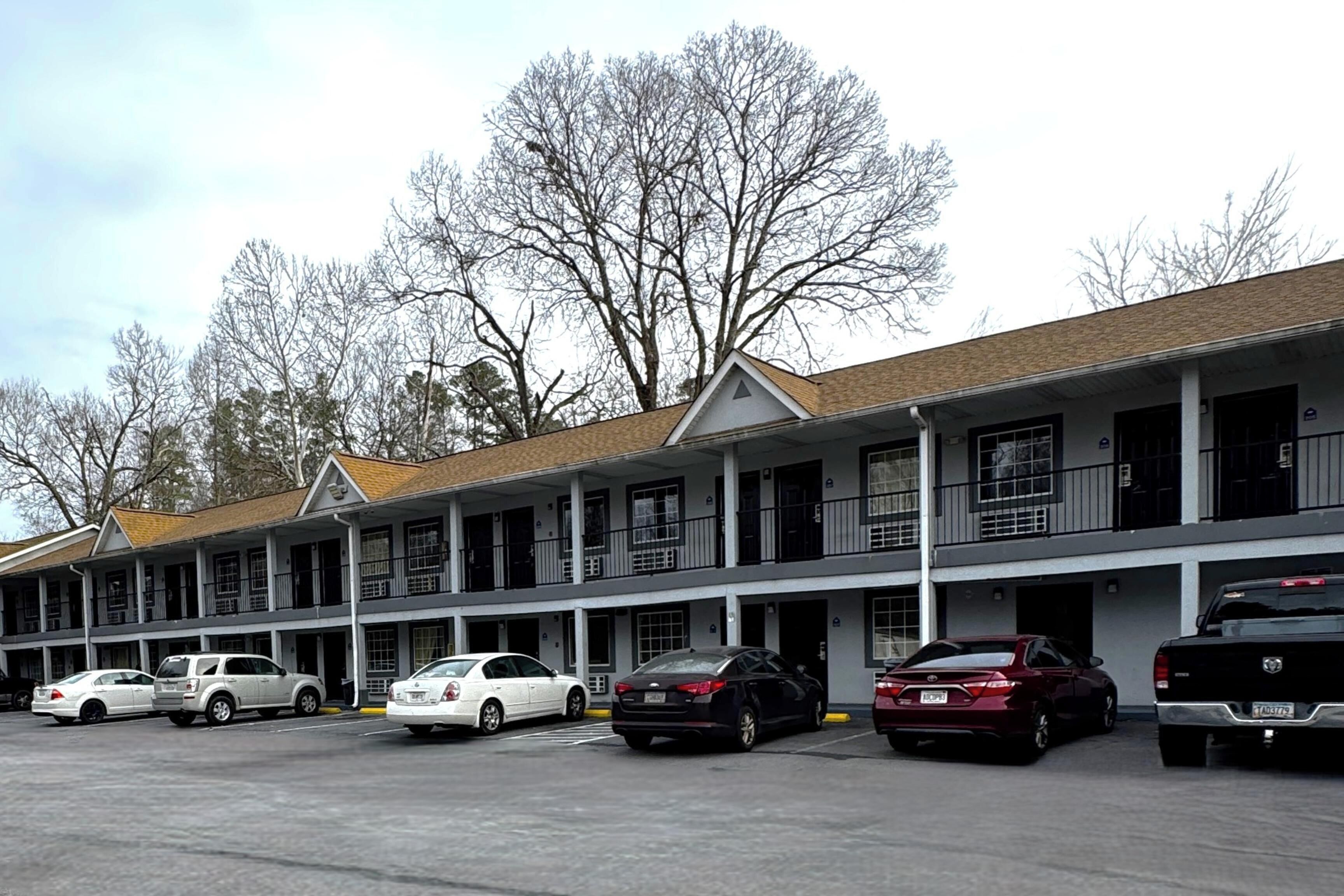 A motel with multiple rooms and a parking lot.