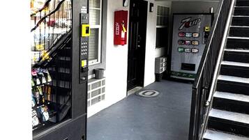 En korridor med en automattankstation, en brandsläckare och ett kylskåp med 7UP-läsk.
