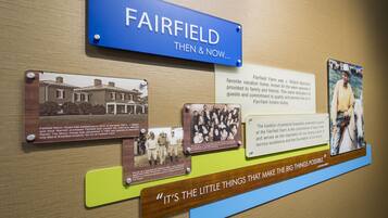 Un panneau d’exposition historique intitulé « FAIRFIELD, HIER ET AUJOURD’HUI », présentant des photos et des textes sur le manoir de Fairfield, son histoire et son importance pour la marque Marriott.