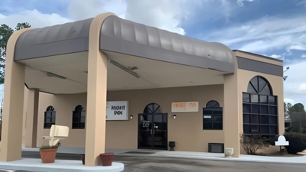 A modern building with a curved roof and large windows. - Night Inn (Rowland)