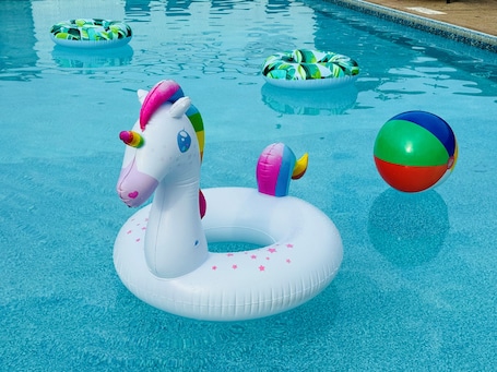 Una piscina al aire libre de temporada, sillones reclinables de piscina