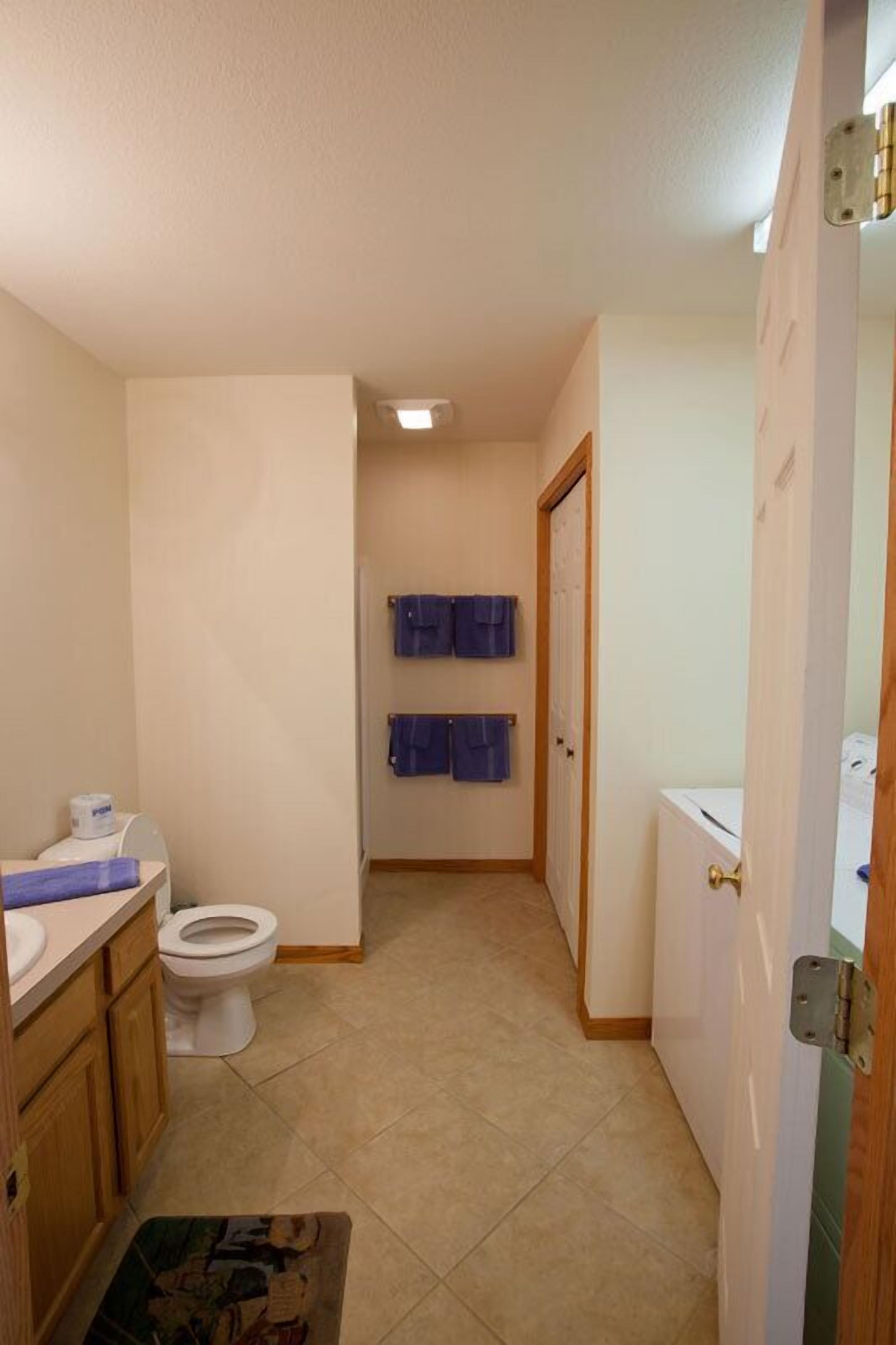 A compact bathroom with a toilet, sink, and a shower area.