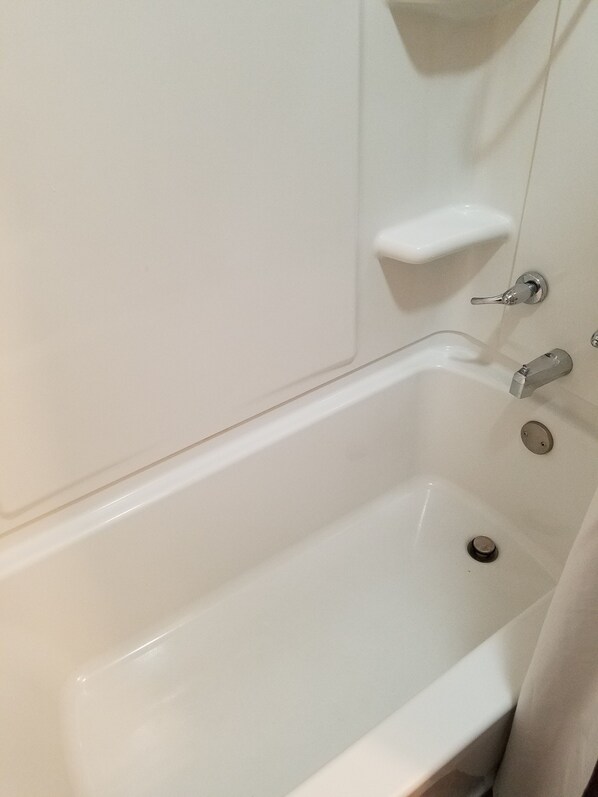 A white bathtub with a faucet and a drain. - Dakota Rose Inn (Underwood)