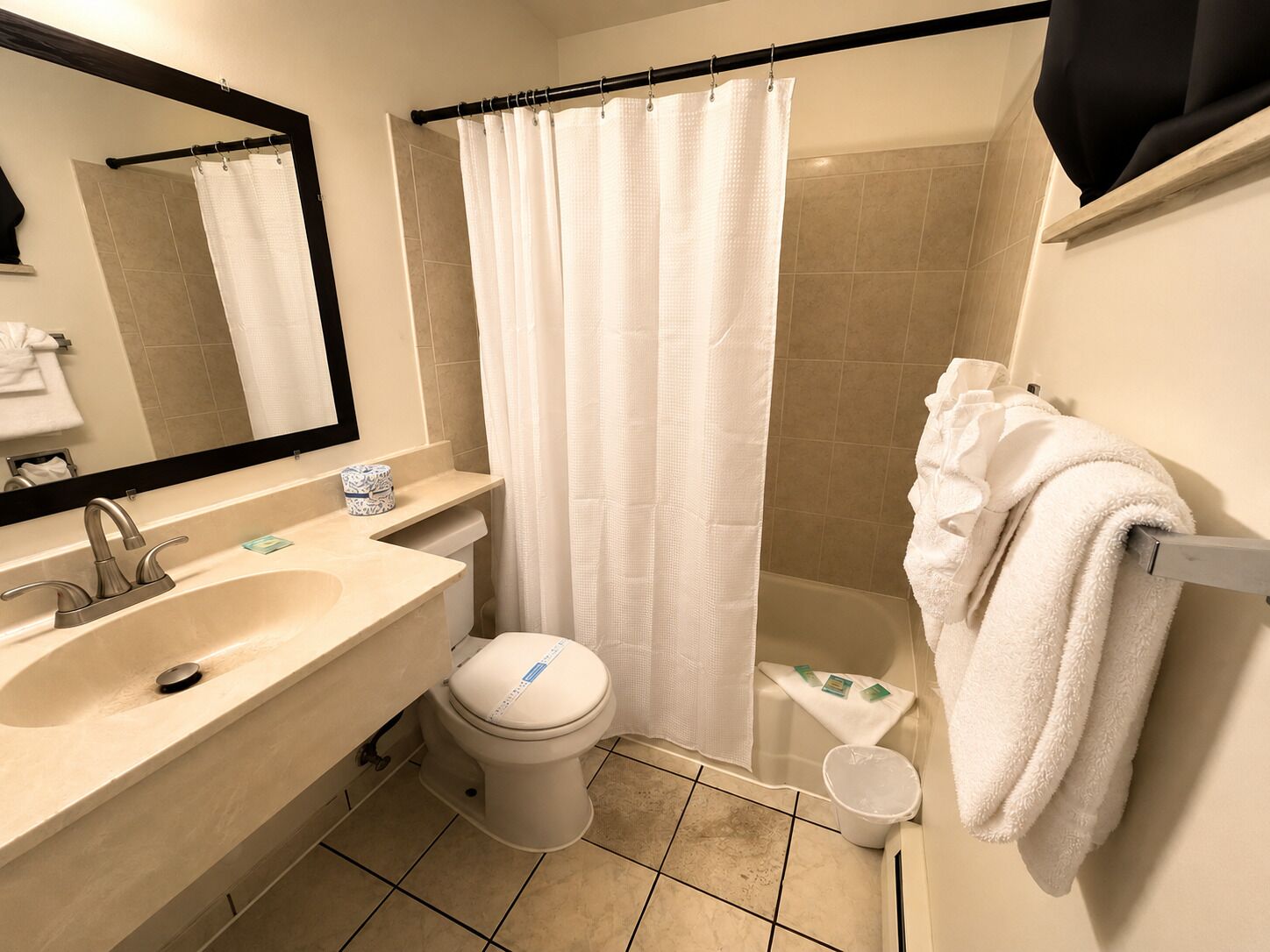 A bathroom with a sink, toilet, and shower curtain.