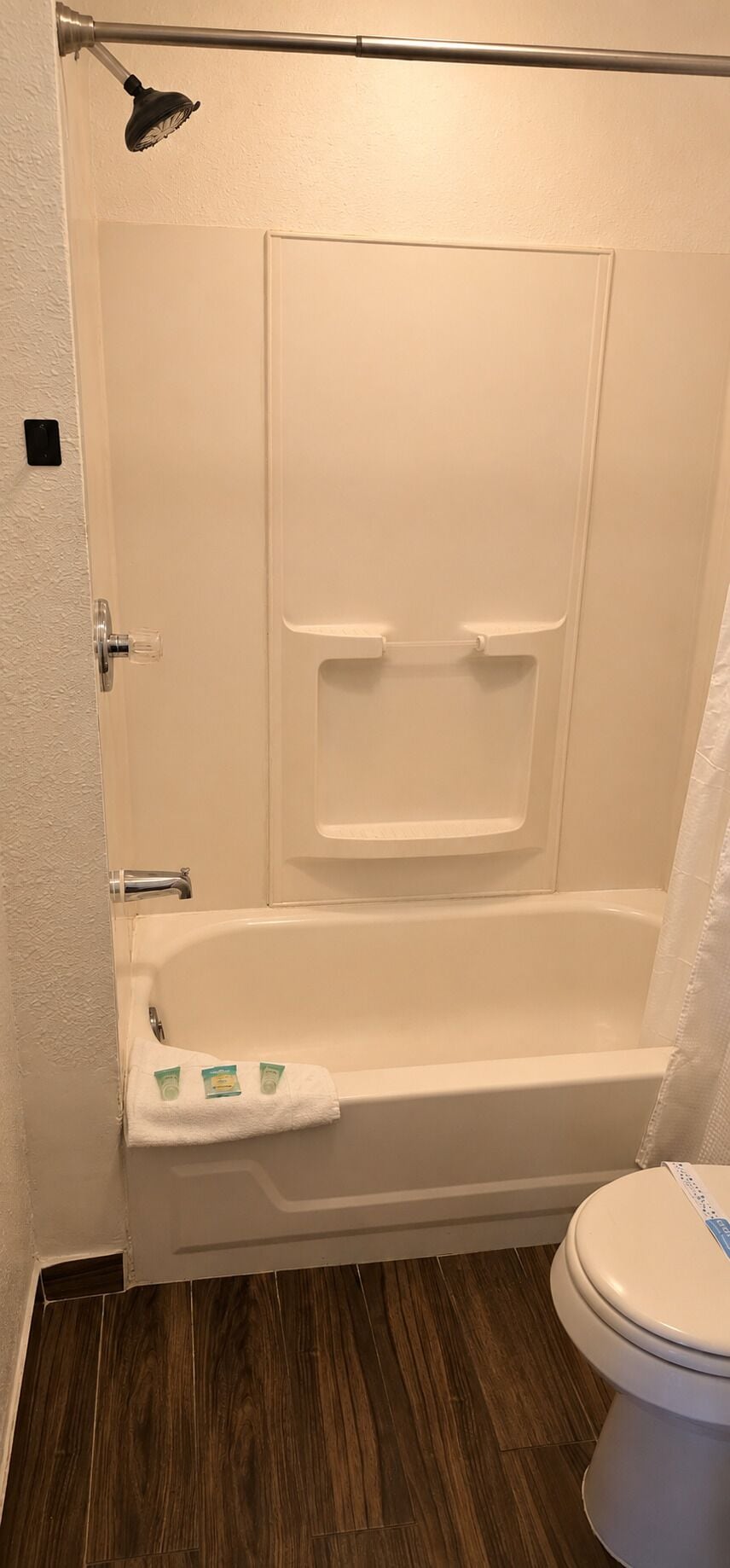 Een badkamer met een badkuip, toilet en een douchegordijn.