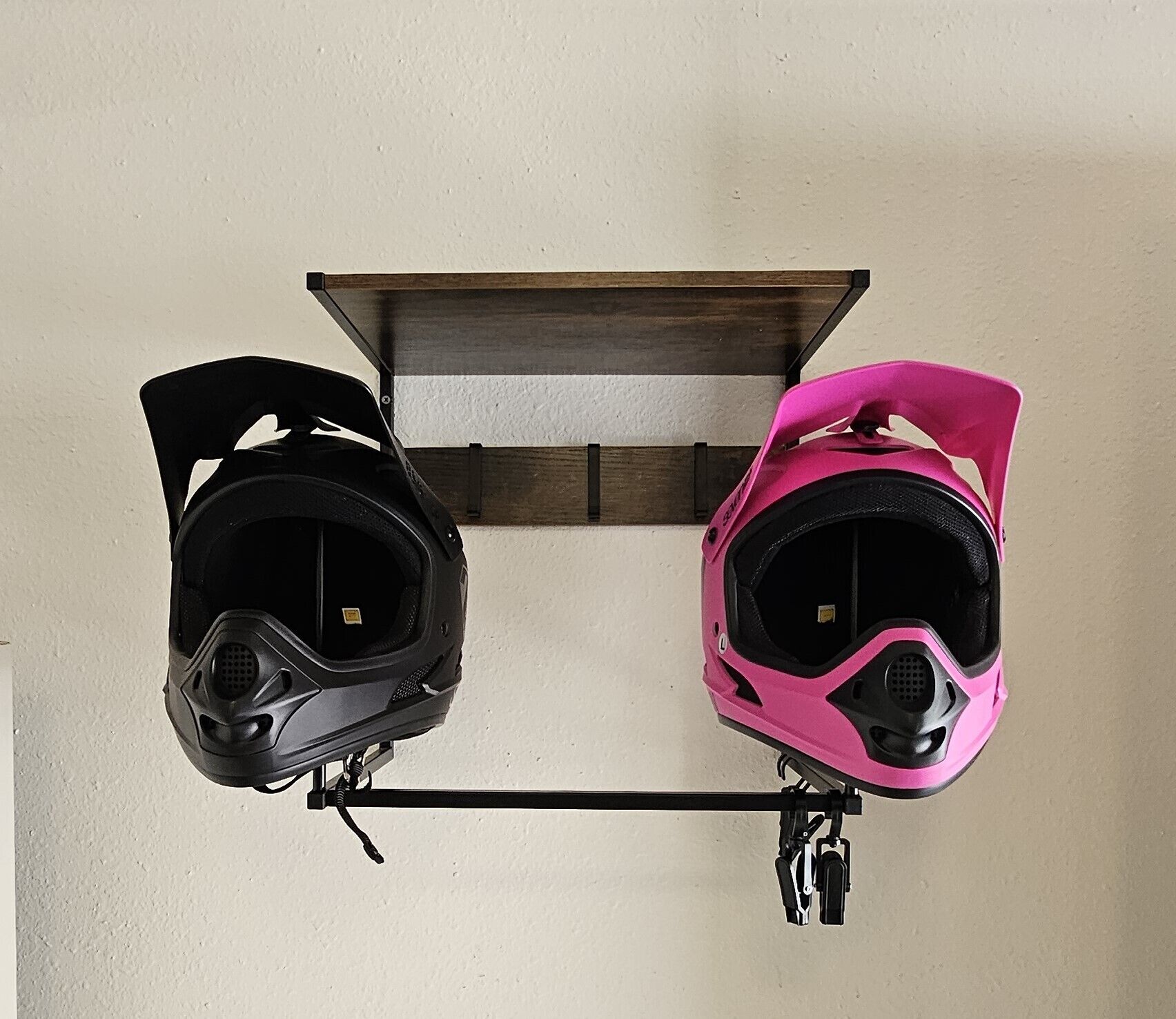 Two helmets mounted on a wall-mounted rack.