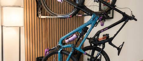 A room with a wooden slat wall, a bicycle mounted on a wall-mounted rack, and a radiator.