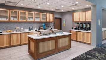 Una cocina moderna con armarios de madera, una isla central y diversos electrodomésticos como una cafetera y un tostador.
