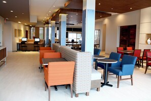 A modern hotel lobby with seating areas, a reception desk, and a visible kitchen in the background. - Holiday Inn Express & Suites Duluth North - Miller Hill by IHG (Duluth)