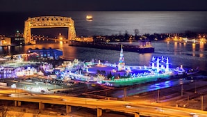 A nighttime view of a waterfront area with illuminated buildings and a bridge. - Holiday Inn Express & Suites Duluth North - Miller Hill by IHG (Duluth)