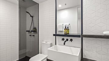 Ein modernes Badezimmer mit Toilette, Waschbecken und Dusche.