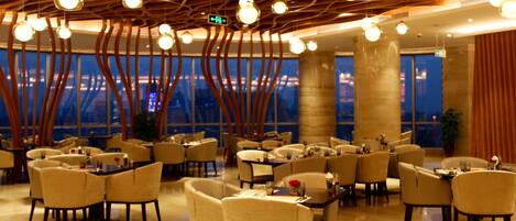 Un restaurant moderne doté d’un plafond au design original, de grandes fenêtres et de sièges confortables.