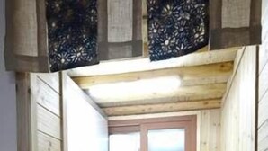 Una cocina compacta con paredes de madera, una ventana y electrodomésticos básicos.