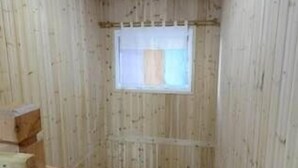 Interior de madera con una escalera, una ventana y una planta en maceta.