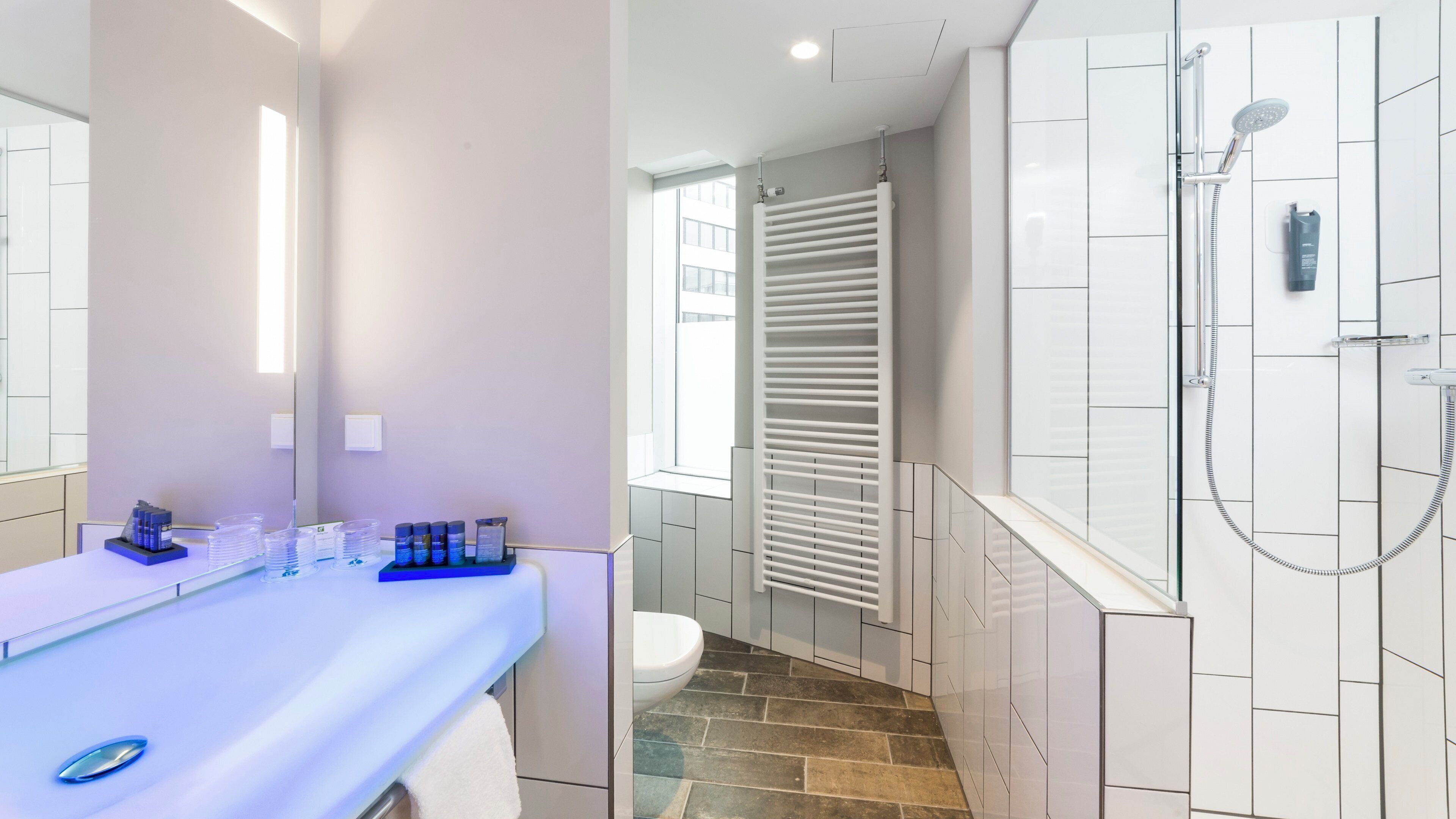 A modern bathroom with a shower, toilet, and vanity.