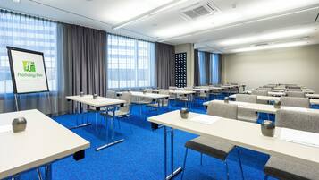 Ein Konferenzraum mit Tischen, Stühlen, einer Projektionsleinwand und Blick auf Hamburg.