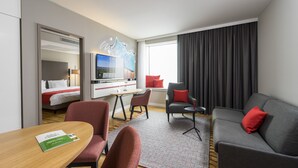 Une chambre d’hôtel comprenant un lit, un bureau avec un ordinateur, un canapé et une télévision.