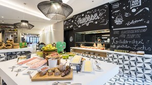 Eine Speiseauslage mit verschiedenen Fleisch-, Käse- und Obstsorten.
