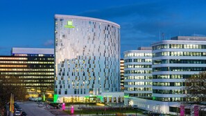 Un hotel moderno con fachada curva, varios pisos y un llamativo letrero de Holiday Inn.