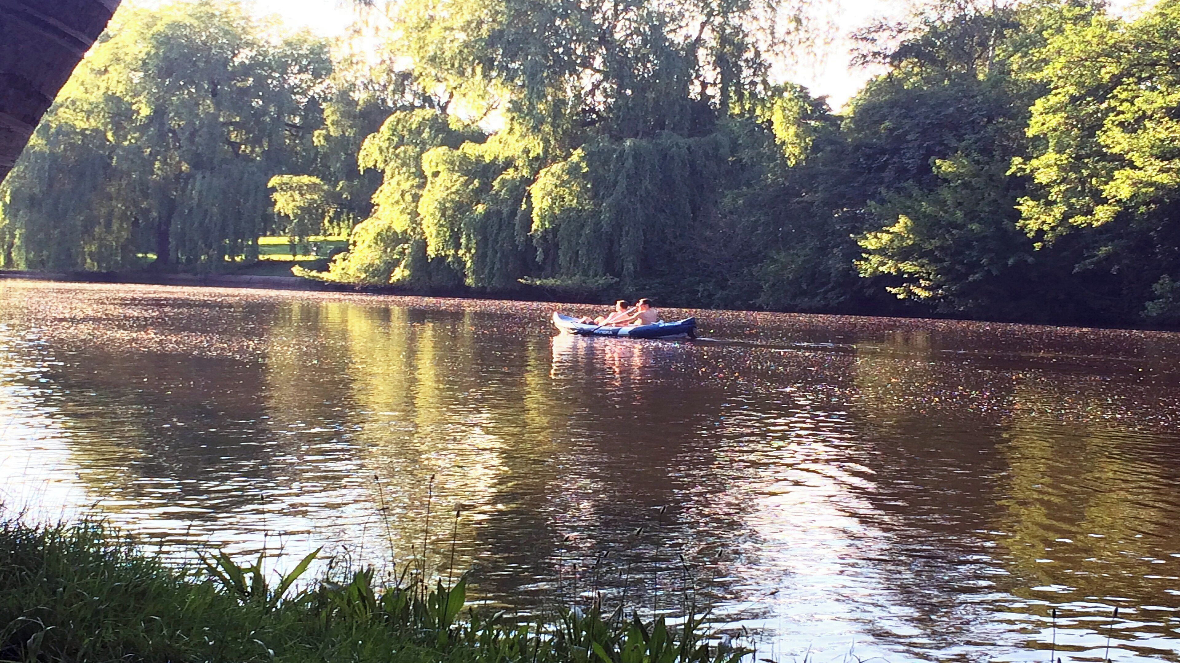 A calm river with a boat carrying people.