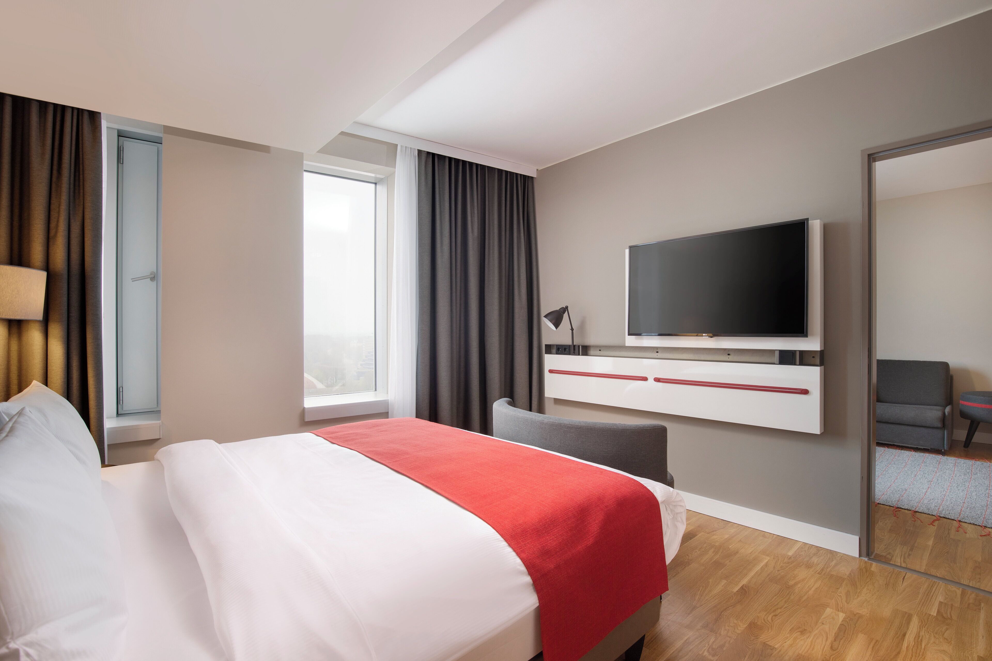 Une chambre d’hôtel avec un lit, une télévision, un bureau et une chaise.