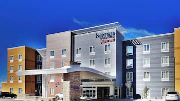 A Fairfield Inn & Suites by Marriott hotel with a modern design, a covered entrance, and a parking lot.