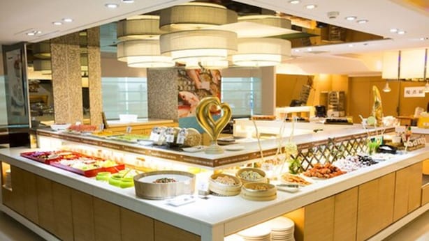 Un bufé con diversas opciones de comida y una decoración con forma de corazón.