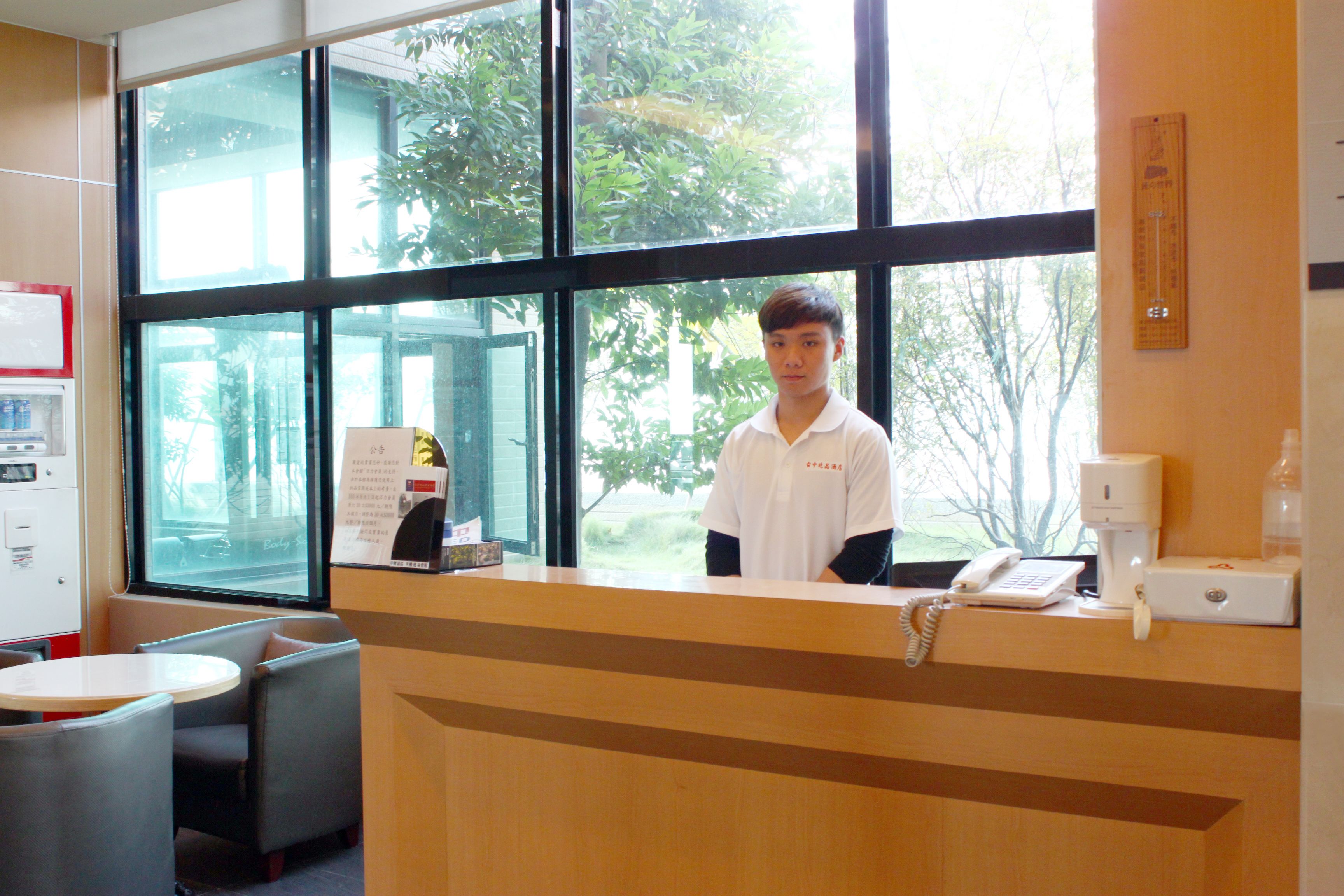 A reception desk with a view of trees outside.