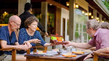 Guests can enjoy casual dining in this outdoor setting with a view of lush greenery.