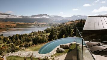 Ein Pool mit Blick auf einen See und Berge im Hintergrund.