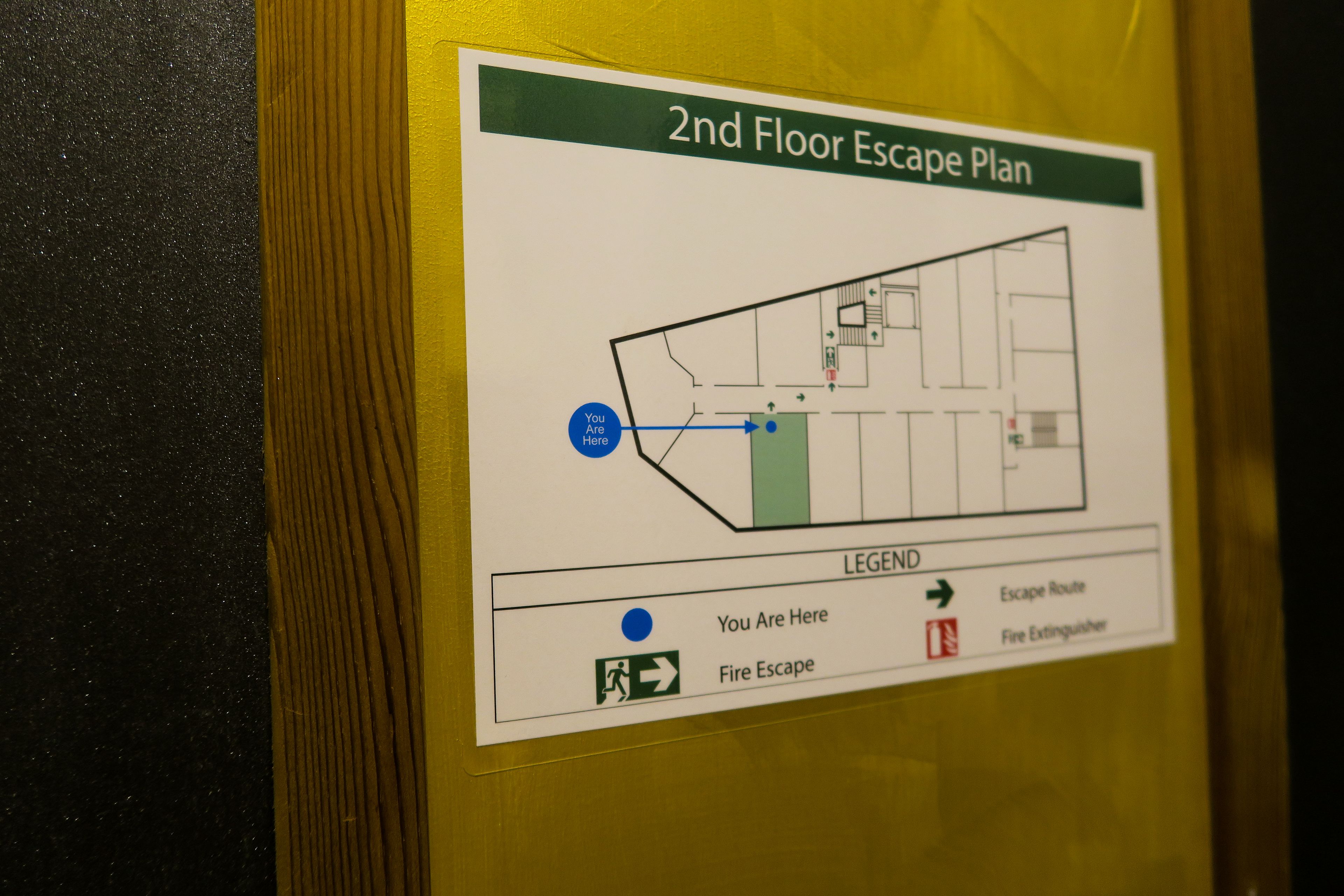 Plan de evacuación del segundo piso con leyenda que indica rutas de escape y ubicación de extintores.