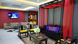A modern living room with a sofa, chairs, a coffee table, and a TV. - Chiangmai SP Hotel (Chiang Mai)