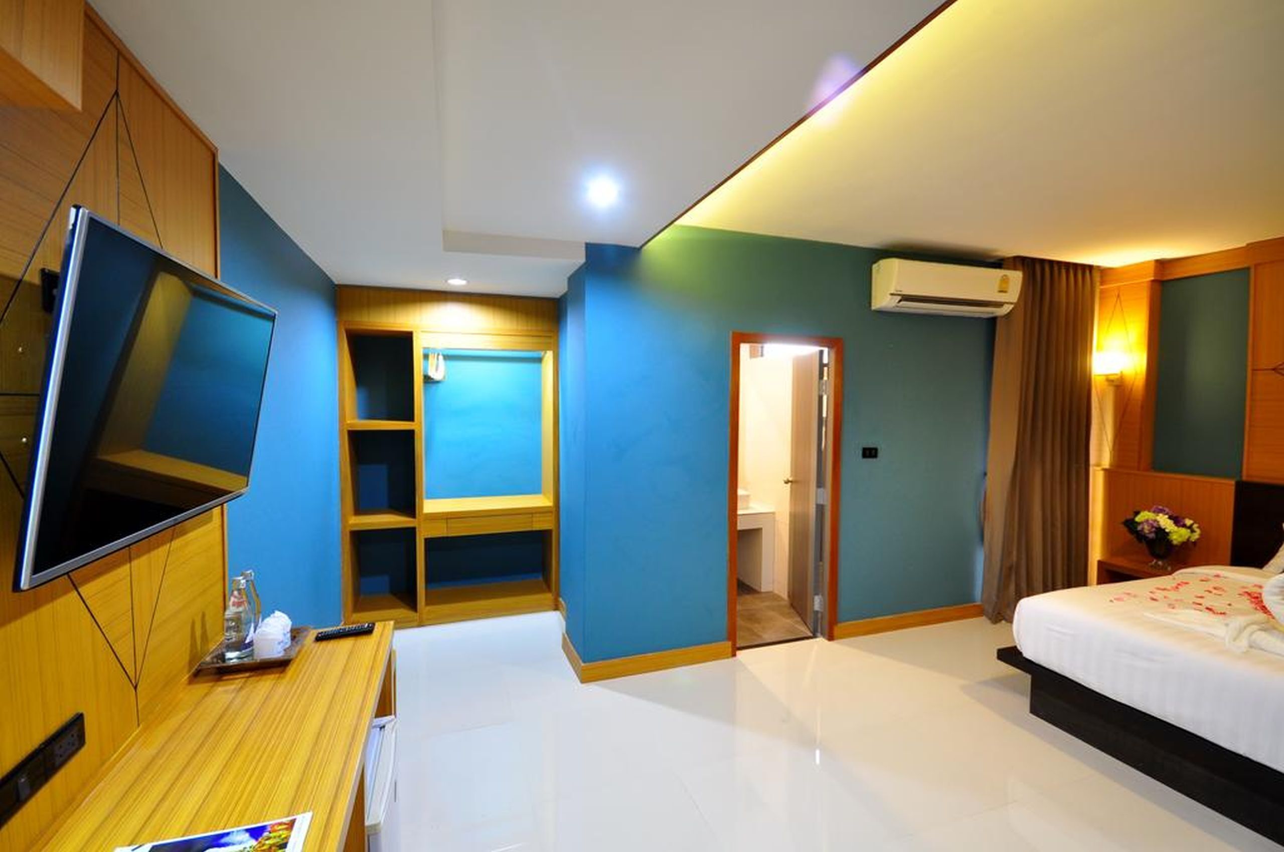 A hotel room with a bed, a TV, a desk, and a wardrobe.