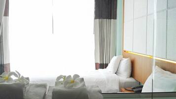 Habitación de hotel con cama, mesita de noche y espejo que refleja el cuarto.