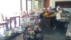 Montaje de bufé con diferentes alimentos y un arreglo floral.