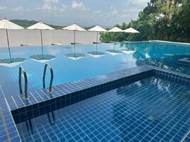 Una piscina al aire libre, sillones reclinables de piscina